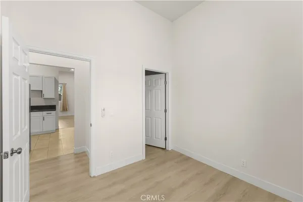 an empty room with wooden floor and a bathroom
