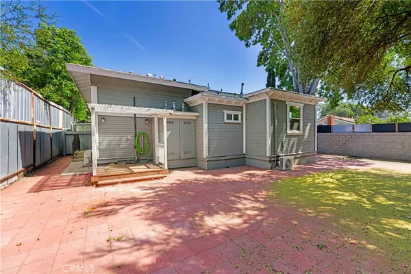 a view of a house with backyard and a patio