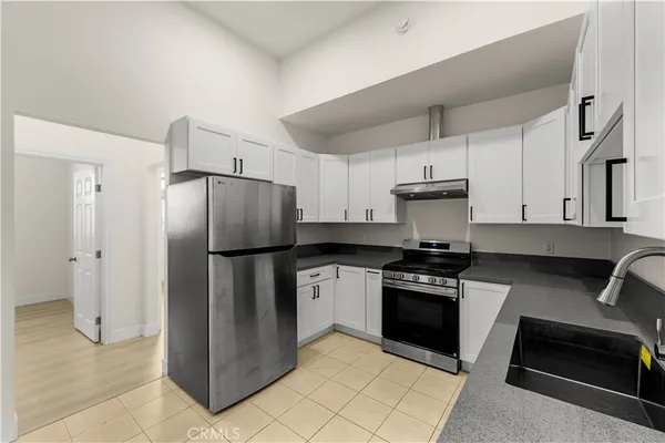 a kitchen with a refrigerator a stove and cabinets