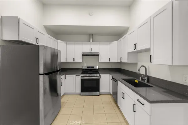 a kitchen with stainless steel appliances granite countertop a refrigerator sink and cabinets