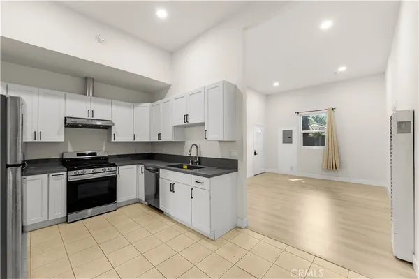 a kitchen with stainless steel appliances granite countertop a stove a sink and a refrigerator