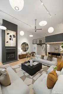 a living room with furniture a fireplace and a large mirror
