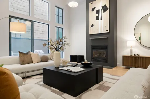 a living room with furniture fireplace and a large window