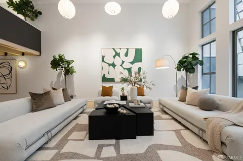 a living room with furniture a potted plant and a large window