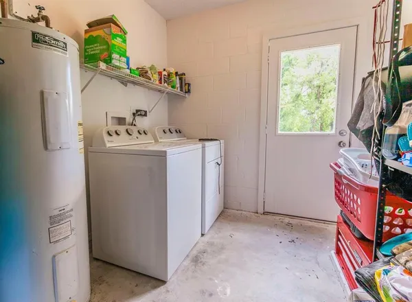 a utility room with fridge dryer and window