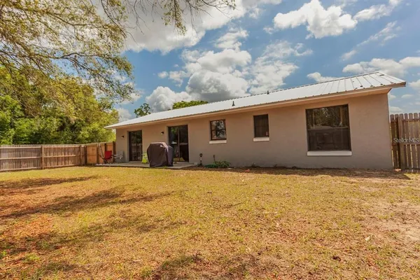 a front view of house with yard and trees in the background
