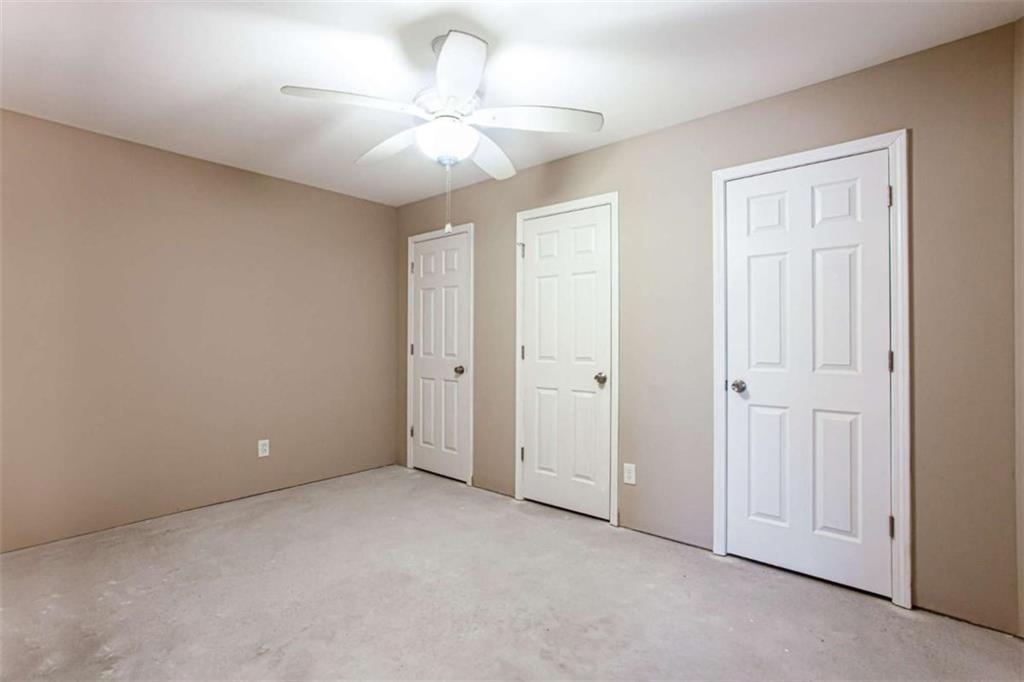 3721 Bogan Mill Road Northeast Buford, GA 30519 - Photo 51 of 58 an empty room with a chandelier fan and windows