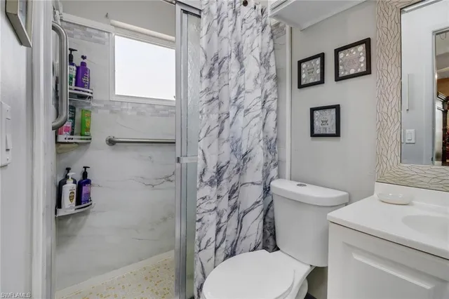 a white toilet sitting next to a bathroom sink and vanity