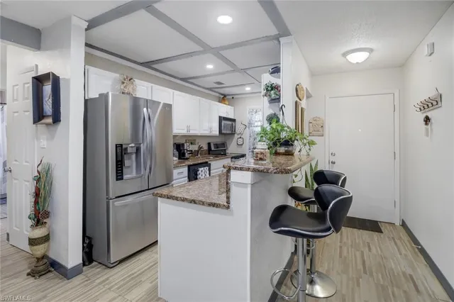 a kitchen with stainless steel appliances a refrigerator and a table