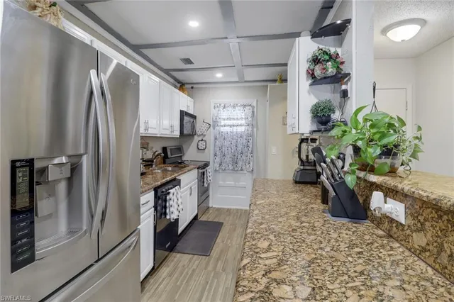 a large kitchen with stainless steel appliances granite countertop a refrigerator