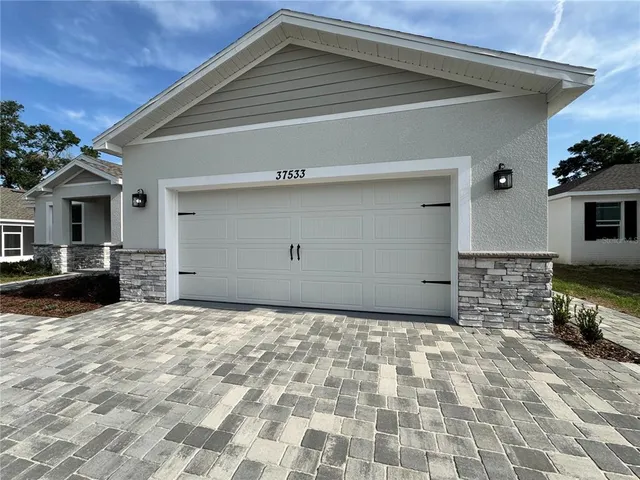 an empty room with windows and ceiling fan