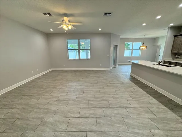 a large kitchen with stainless steel appliances kitchen island a large counter top and a stove top oven