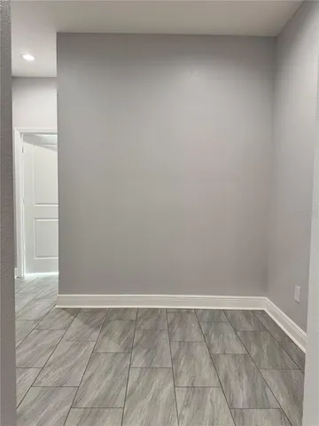 a view of an empty room with wooden floor and closet