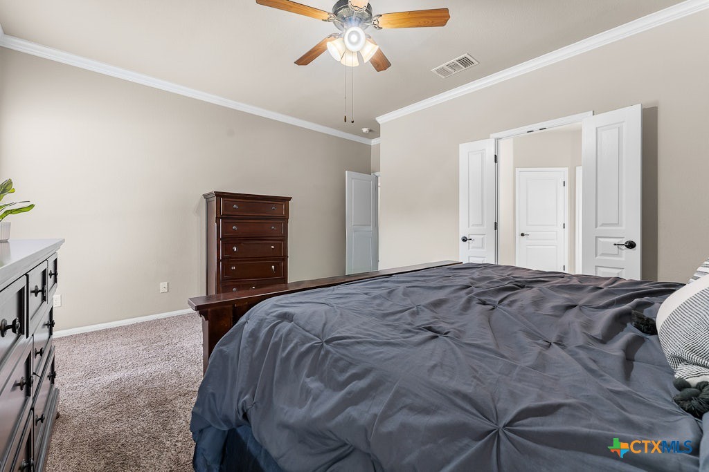 430 Archstone Loop Belton, TX 76513 - Photo 16 of 40 a bedroom with a bed and a chandelier