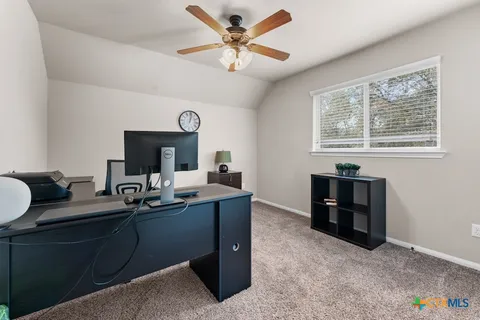 a view of a workspace with furniture and a window