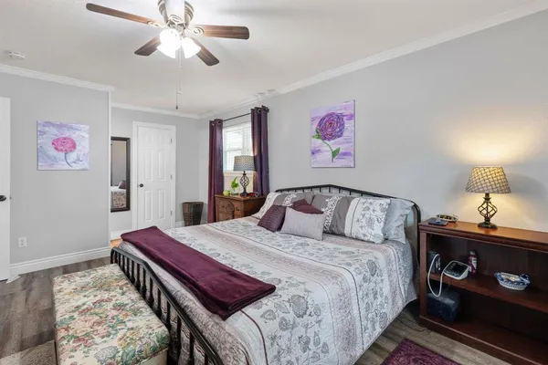 a bedroom with a bed and a lamp on dresser