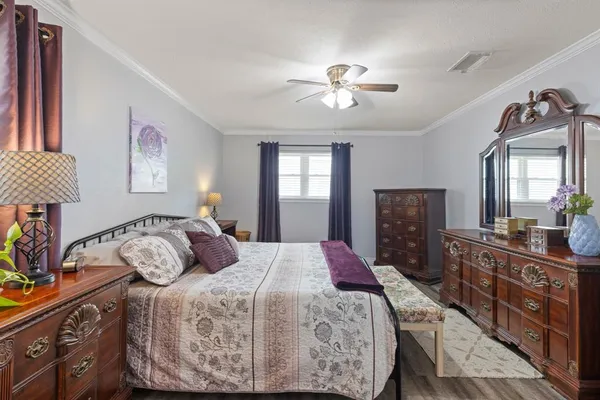 a bedroom with a bed a dresser next to a window