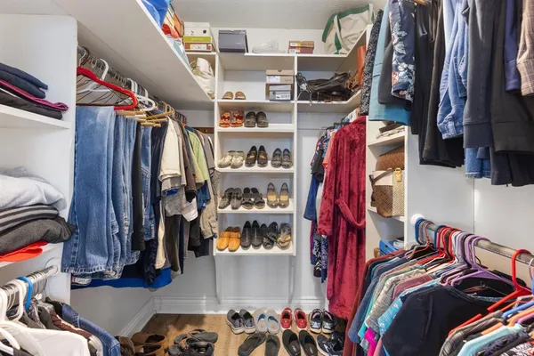 a view of walk in closet with clothes and shoes