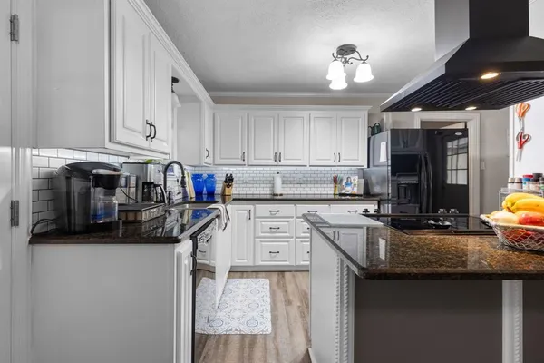 a kitchen with cabinets appliances a sink and a counter top space