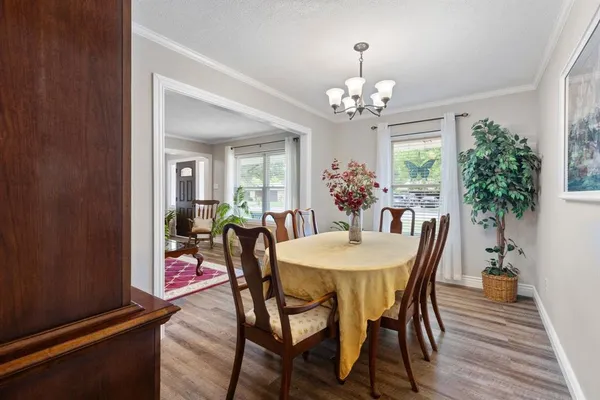 a view of a dining room with furniture a chandelier and wooden floor