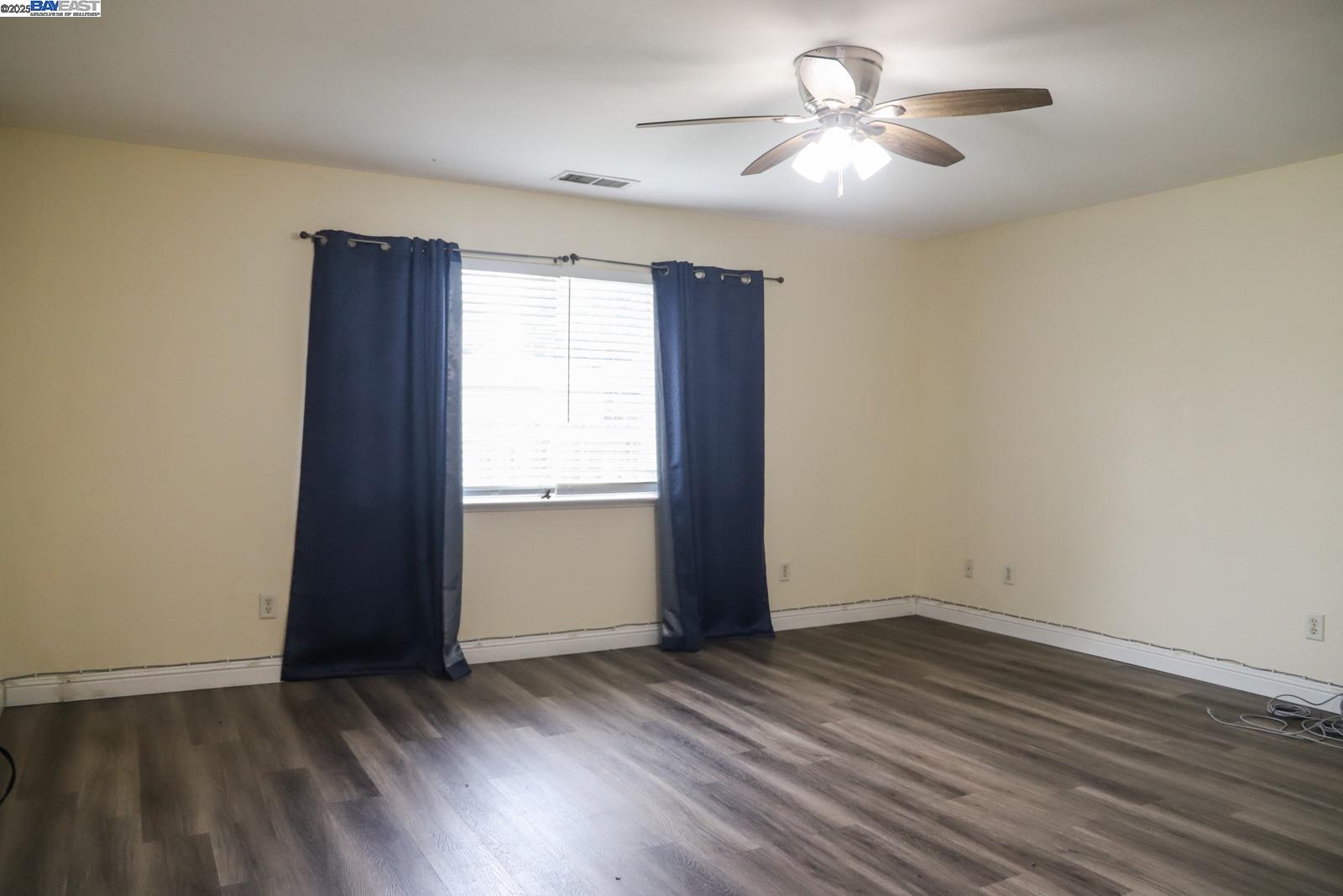 4295 North Archie Avenue Fresno, CA 93726 - Photo 18 of 23 a view of empty room with wooden floor and fan