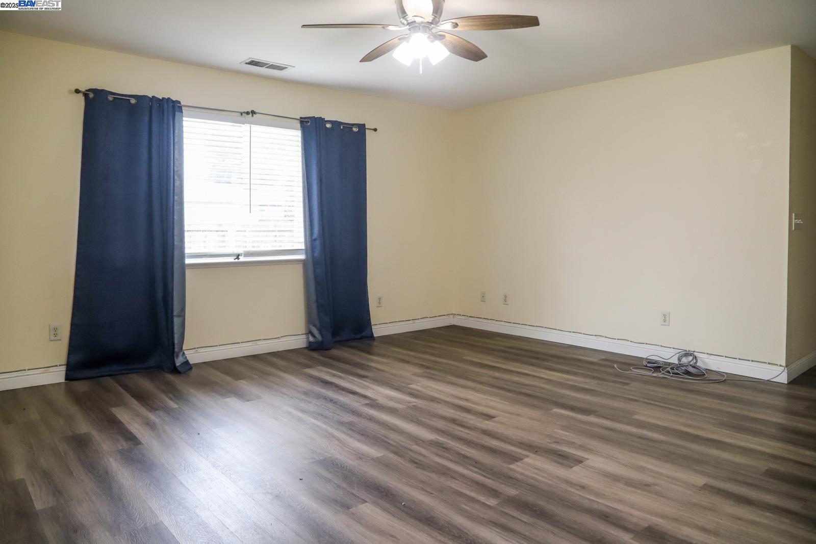 4295 North Archie Avenue Fresno, CA 93726 - Photo 19 of 23 an empty room with wooden floor and windows