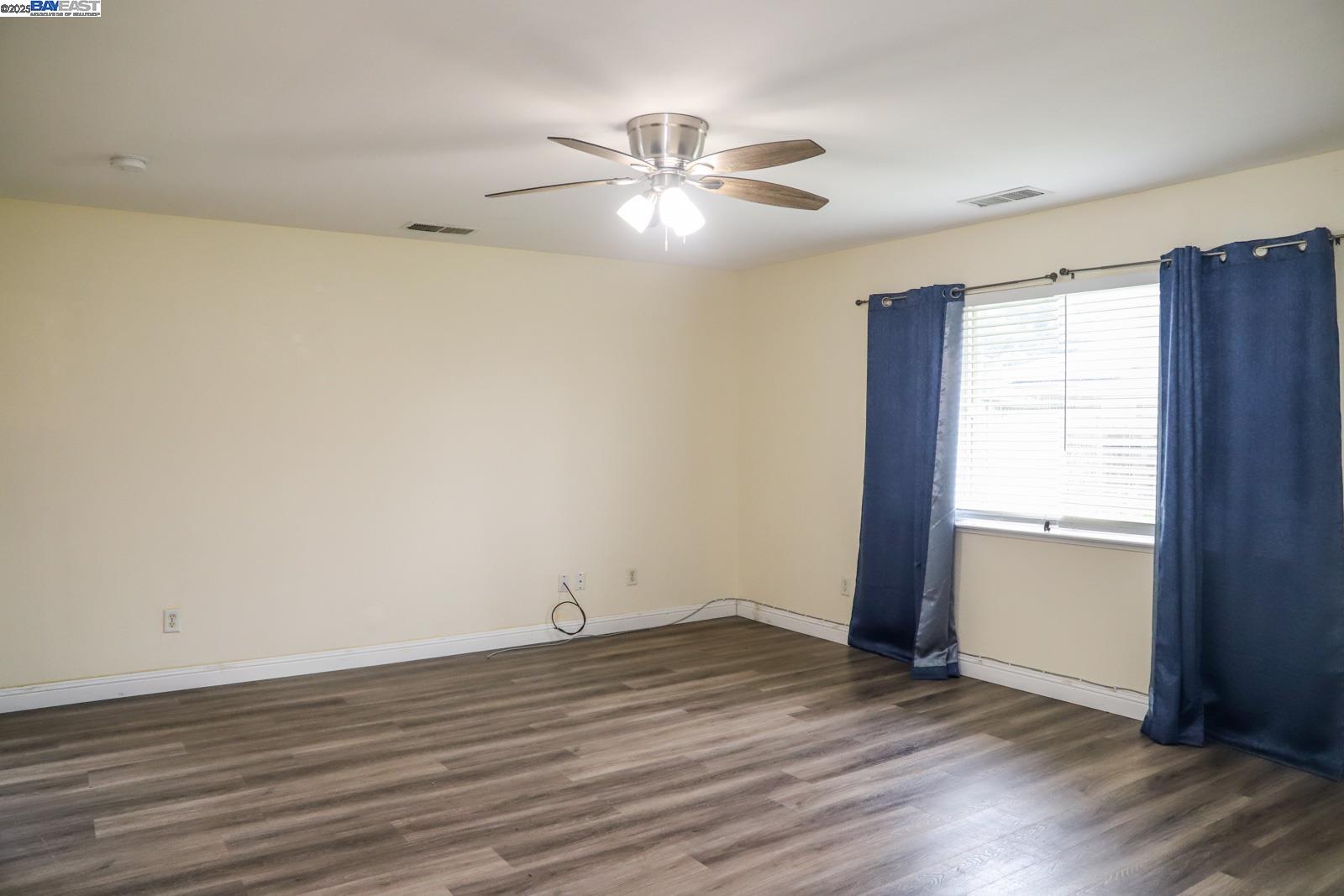 4295 North Archie Avenue Fresno, CA 93726 - Photo 20 of 23 an empty room with wooden floor and windows