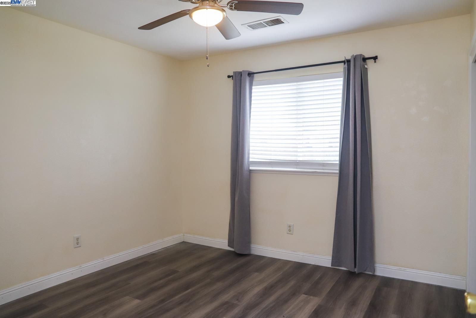 4295 North Archie Avenue Fresno, CA 93726 - Photo 5 of 23 an empty room with wooden floor and windows