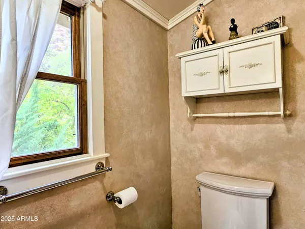 a bathroom with a toilet a sink and a window