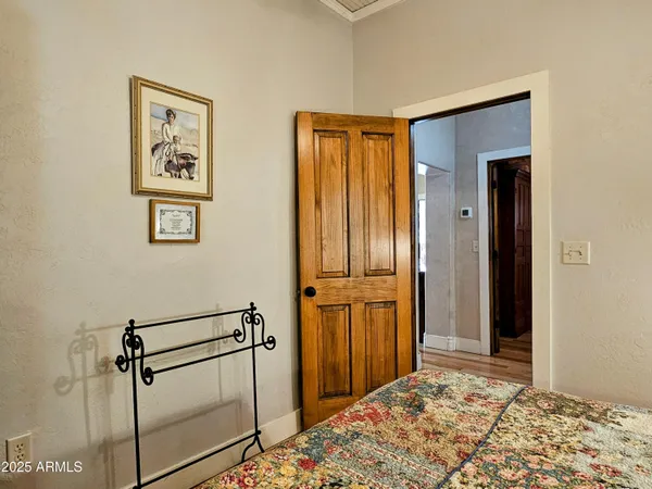 a view of a bedroom with wooden floor and bathroom