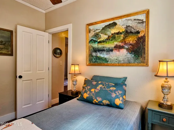 a bedroom with a bed and a painting on the wall