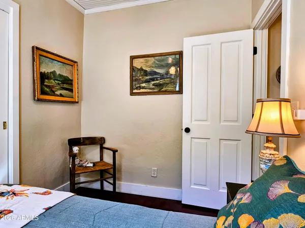 a bedroom with a bed and a lamp on dresser