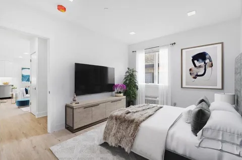 a bedroom with a bed and a flat screen tv