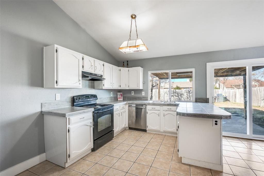 a kitchen with stainless steel appliances granite countertop a stove sink and cabinets