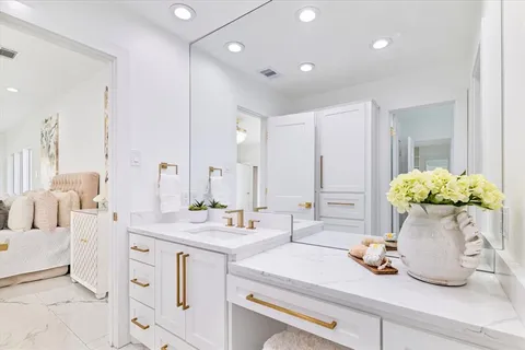 a room with white cabinets and chandelier