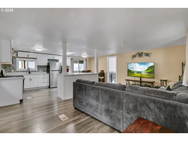 a living room with stainless steel appliances kitchen island granite countertop a living room view dining table and chair