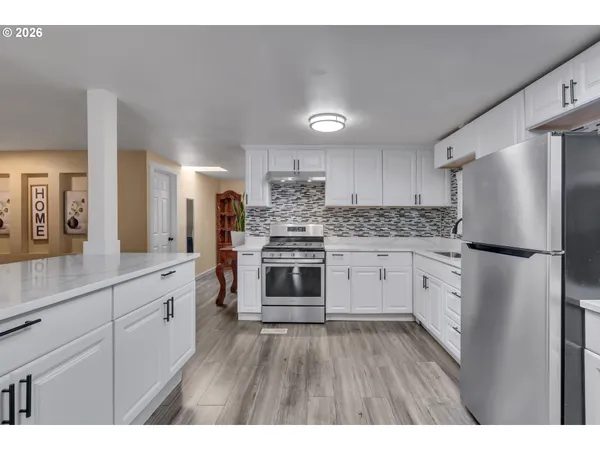 a kitchen with white cabinets and stainless steel appliances