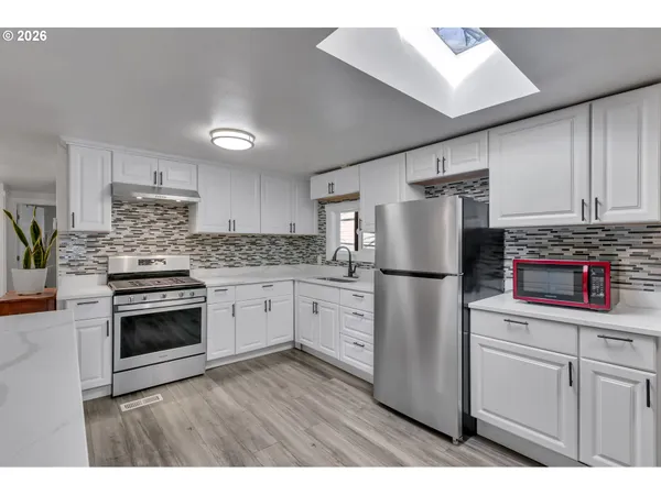 a kitchen with stainless steel appliances a refrigerator sink and cabinets