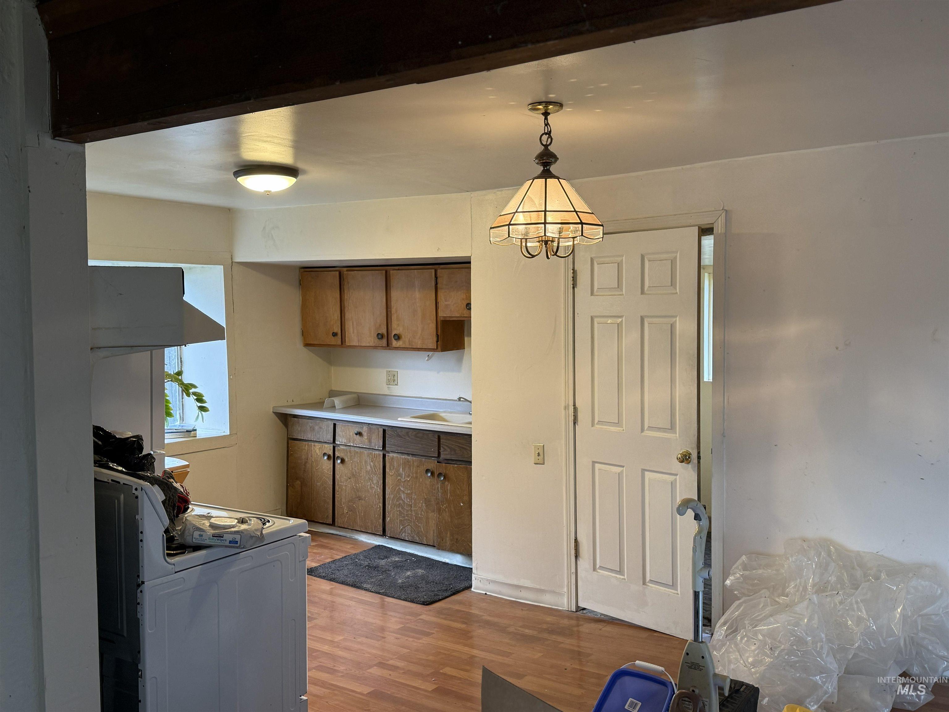 838 11th Street Clarkston, WA 99403 - Photo 3 of 20 Kitchen with white range, light wood-type flooring, light countertops, wood finish cabinetry, and hanging lights