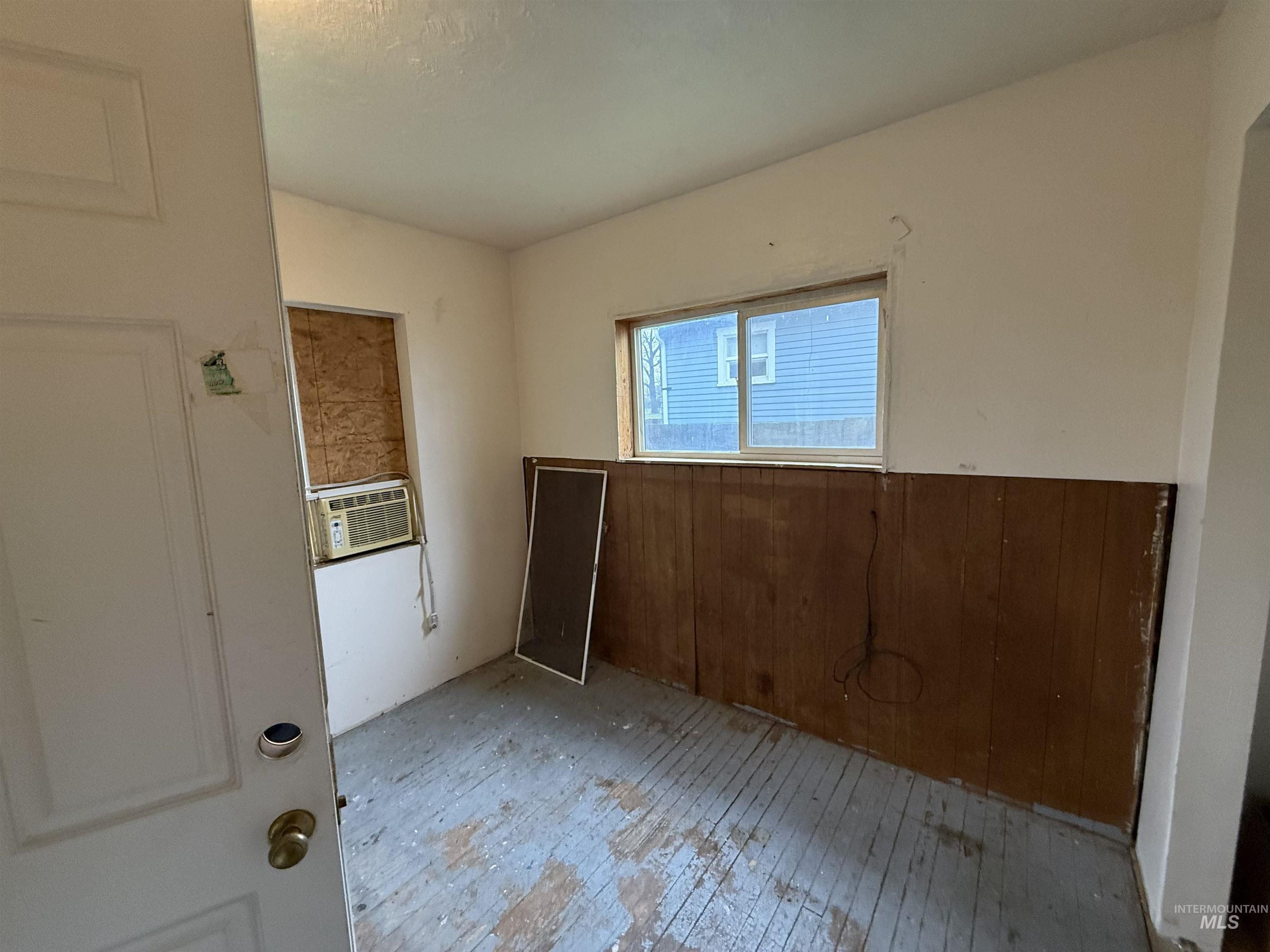 838 11th Street Clarkston, WA 99403 - Photo 6 of 20 Unfurnished room with hardwood / wood-style flooring and wood walls