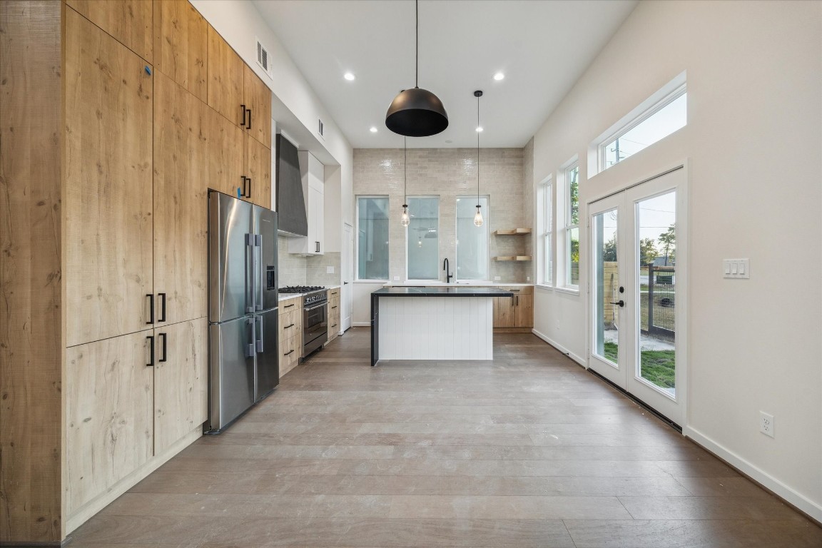 3903 Yale Street Houston, TX 77018 - Photo 3 of 45 A spacious kitchen with wooden cabinets, stainless steel appliances, and large windows letting in natural light.