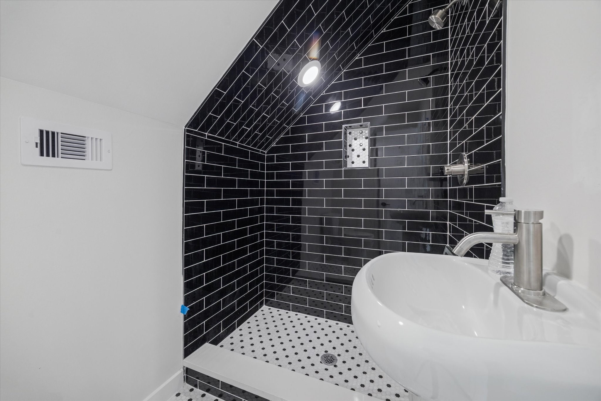 3903 Yale Street Houston, TX 77018 - Photo 5 of 45 This sleek bathroom features black subway tile framing the shower and modern fixtures.