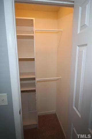 a view of walk in closet with empty racks