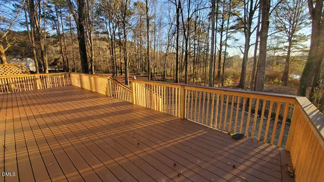a view of deck with wooden floor and fence next to a yard