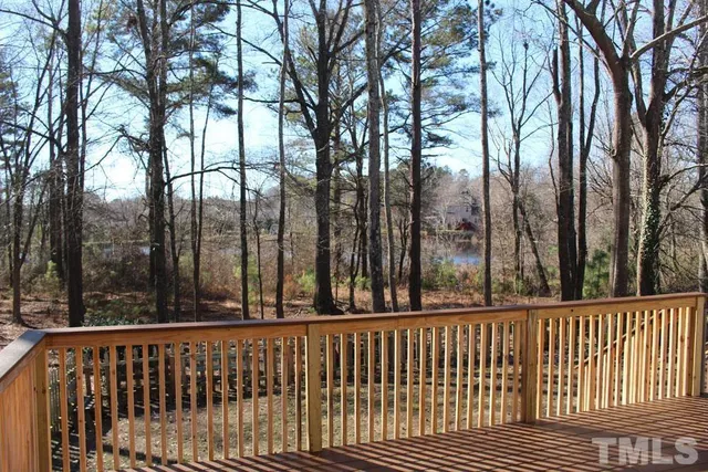 a view of deck with wooden floor and fence next to a yard