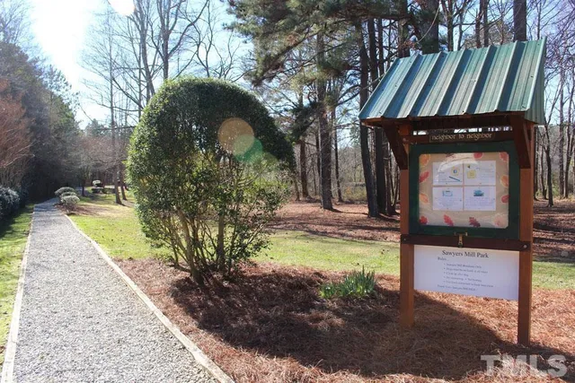 a front view of a house with garden and trees