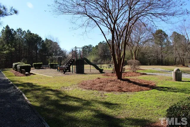 a view of a fire pit with large trees