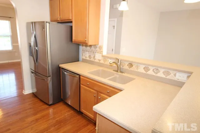 an empty room with wooden floor fireplace and windows