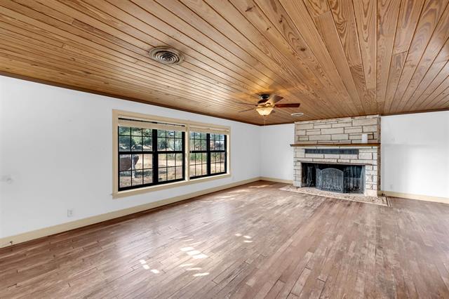 8164 Ranch Road 261 Buchanan Dam, TX 78609 - Photo 13 of 20 a view of an empty room with wooden floor fireplace and a window