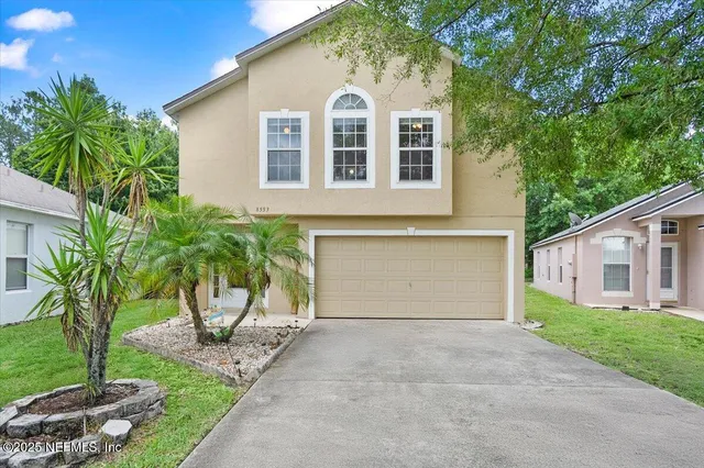 a front view of a house with a yard and garage